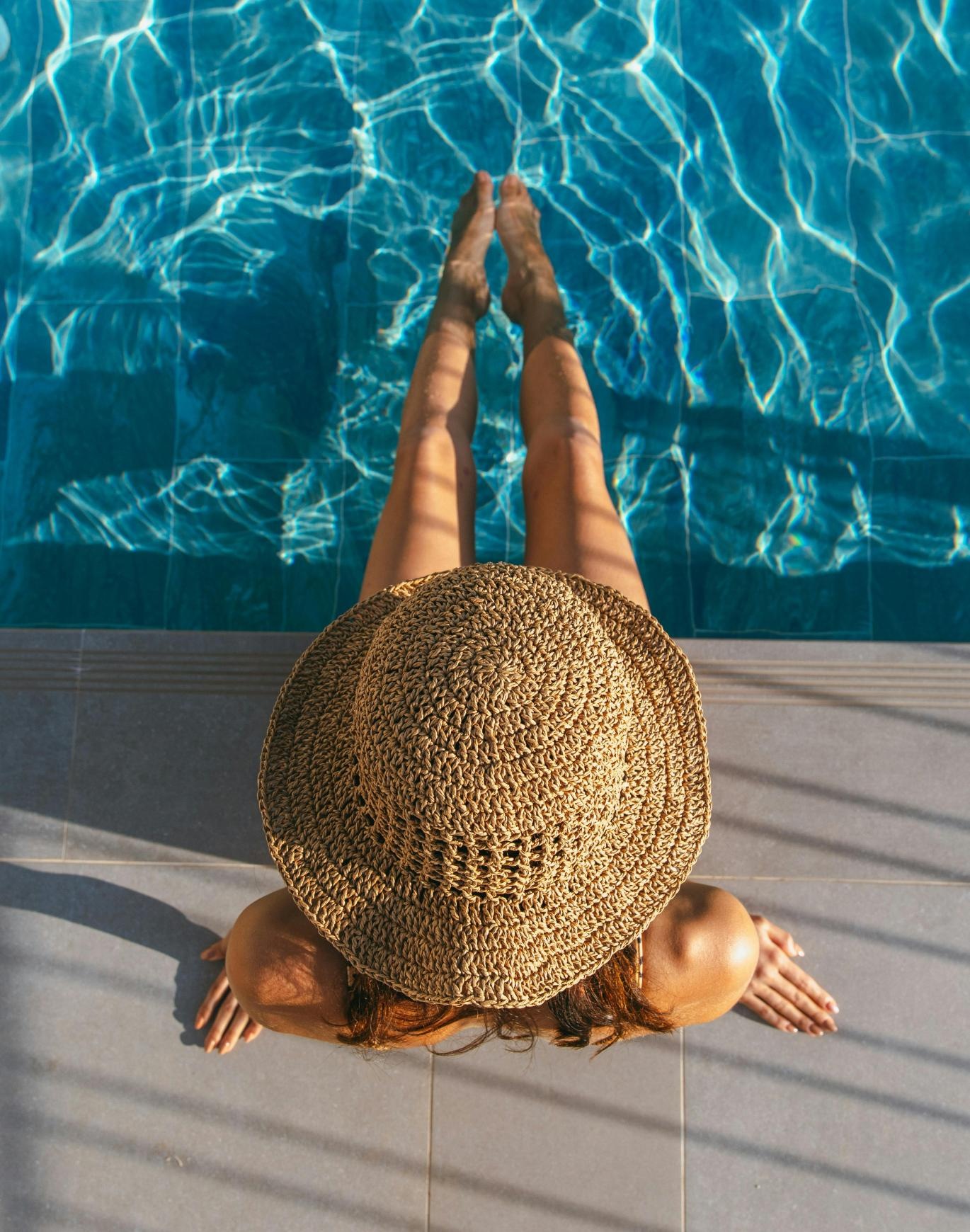 women sunbathing poolside